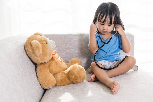 Aziatische Chinese kleine meisje onderzoek teddybeer met stethoscop — Stockfoto