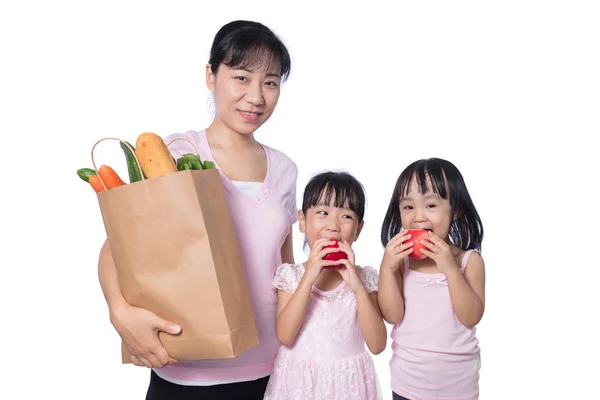 Asiatin und ihre Töchter tragen Lebensmittel — Stockfoto