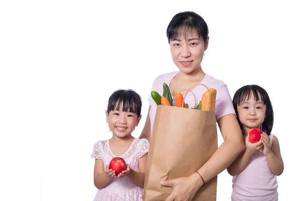 Азиатка и дочери, перевозящие продукты — стоковое фото