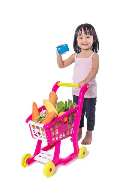 Asian Chinese little girl holding credit card with shopping trol — Stock Photo, Image