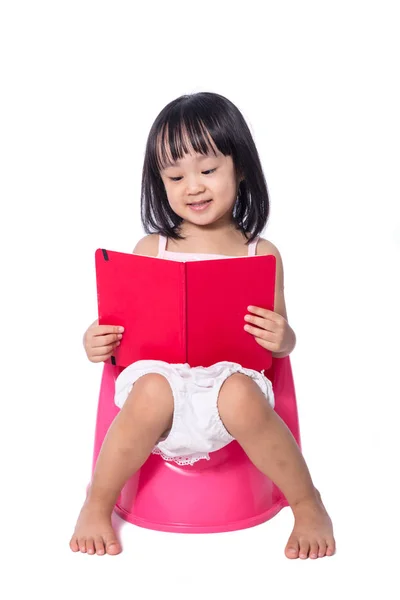 Aziatische Chinees meisje zittend op chamberpot met boek — Stockfoto