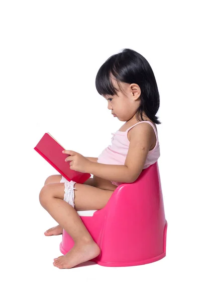 Азіатський китайський дівчинка сидить на chamberpot з книгою — стокове фото