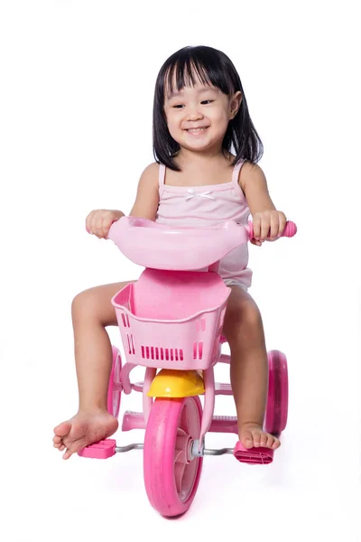 Asian chinese little girl riding a toy tricycle — Stock Photo, Image