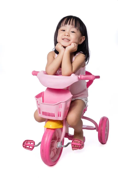 Asiático chinês menina equitação um brinquedo triciclo — Fotografia de Stock