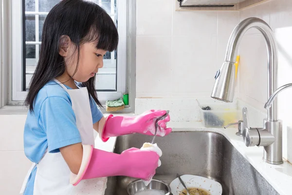 Asian Chinese little girl washing dishes in the kitchen — Stock Photo, Image