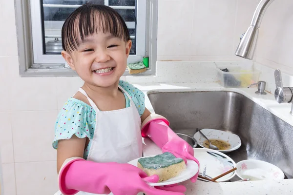 Asian Chinese little girl washing dishes in the kitchen — Stock Photo, Image