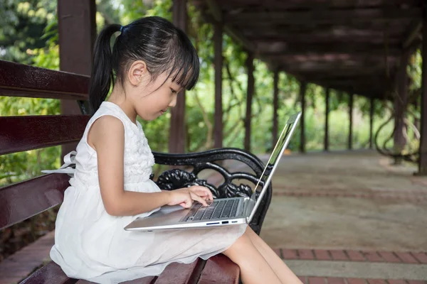 Ázsiai kínai kislány ül a padon, laptop — Stock Fotó