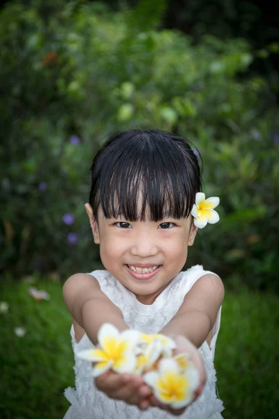 Aziatische Chinese meisje houdt van bloemen in de tuin — Stockfoto