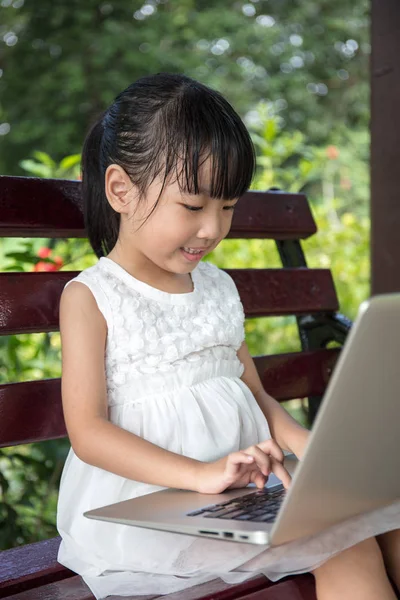 Asiática china niña sentada en el banco con portátil — Foto de Stock