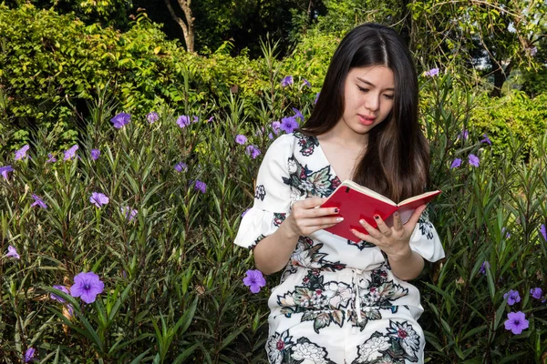 Asiática hermosa joven mujer leyendo un libro en jardín al aire libre —  Fotos de Stock