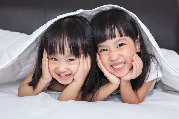 Asijské malé čínské dívky hrající na posteli — Stock fotografie