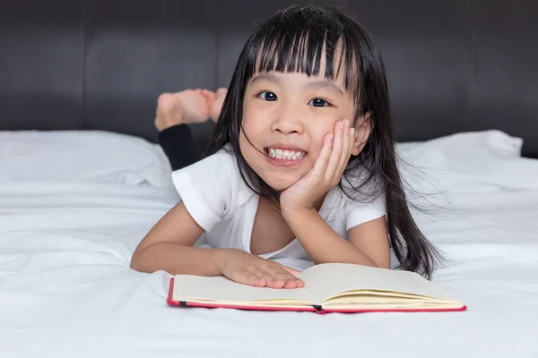 Asiatische kleine chinesische Mädchen lesen ein Buch auf Bett — Stockfoto