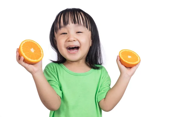 Счастливая азиатская китайская девочка с апельсином в руках — стоковое фото