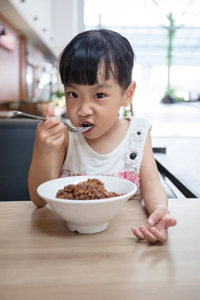 Asijské malé Čínská dívka jíst dušené rýže s vepřovým — Stock fotografie