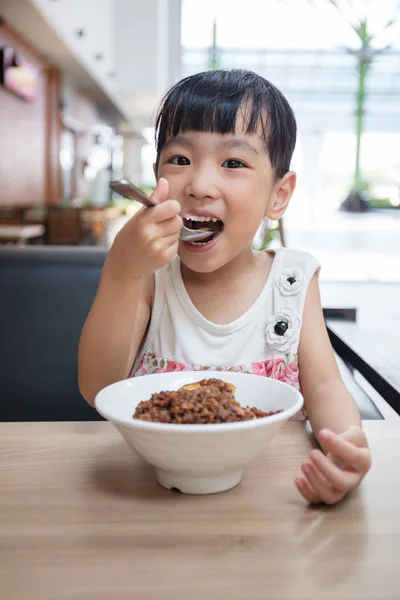 Asiatiska liten kinesisk flicka äter Bräserad fläsk ris — Stockfoto