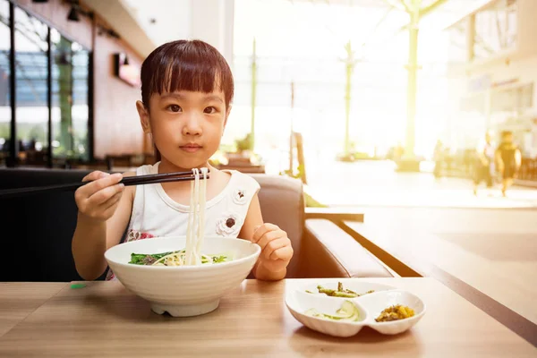 Asiatique petite fille chinoise manger des nouilles de bœuf soupe — Photo