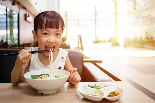 Asiatiska liten kinesisk flicka äter Nötkött nudlar soppa — Stockfoto