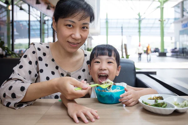 Asian Chinese mother and daughter eating beef noodles — Stock Photo, Image