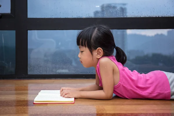 Ασιατικές μικρή Κινέζα διαβάζοντας ένα βιβλίο κοντά στο παράθυρο — Φωτογραφία Αρχείου