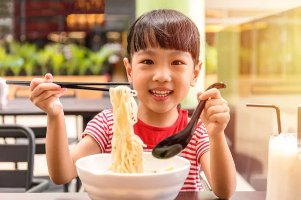 Asiatiska liten kinesisk flicka äter nudlar soppa — Stockfoto