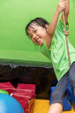 Asyalı Çinli küçük kız bir ip üzerinde sürme