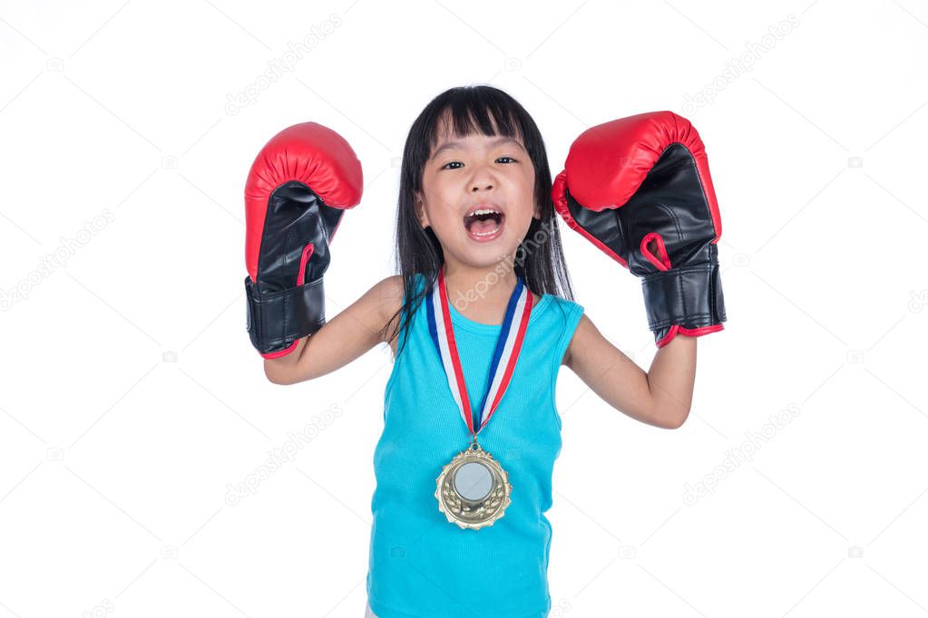 Asian Chinese little girl wearing boxing gloves and celebrating 