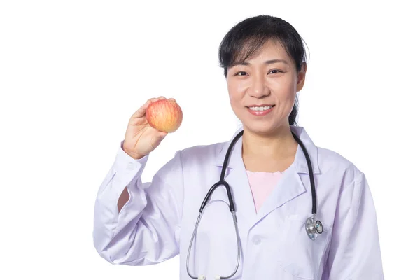 Asiatiska kvinnliga läkare håller apple med stetoskop — Stockfoto