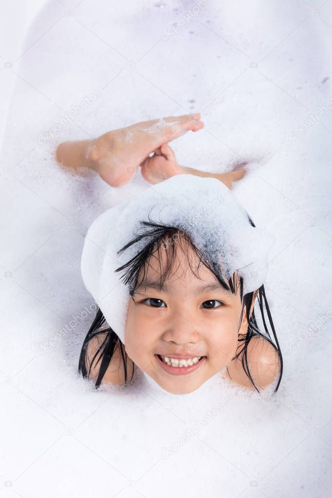 Asian little Chinese girl playing with water and foam