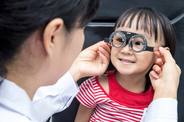 Asyalı küçük Çinli kız yapıyor gözleri bir sınava ophthalmolog