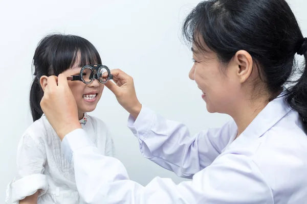 Asyalı küçük Çinli kız yapıyor gözleri bir sınava ophthalmolog