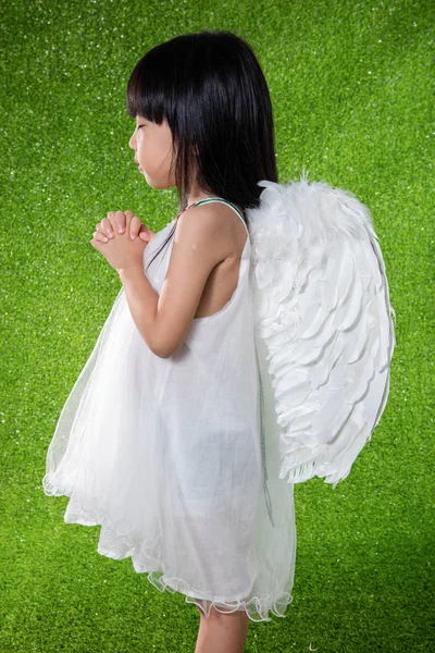 Asiática china niña usando ángel alas y orando — Foto de Stock