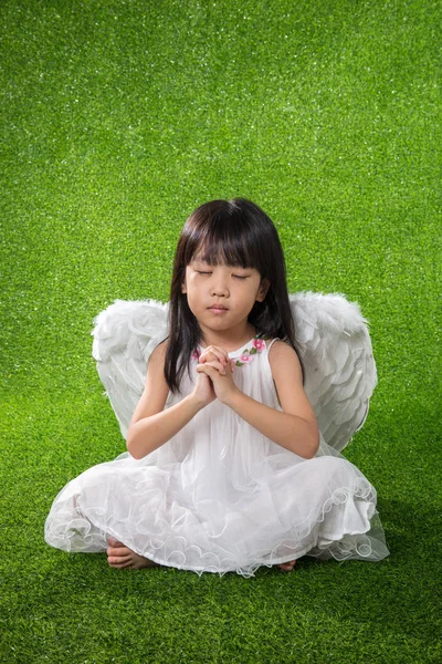 Asian Chinese little girl wearing angel wings and praying — Stock Photo, Image