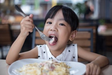 Asyalı Çinli küçük kız spagetti yemek 