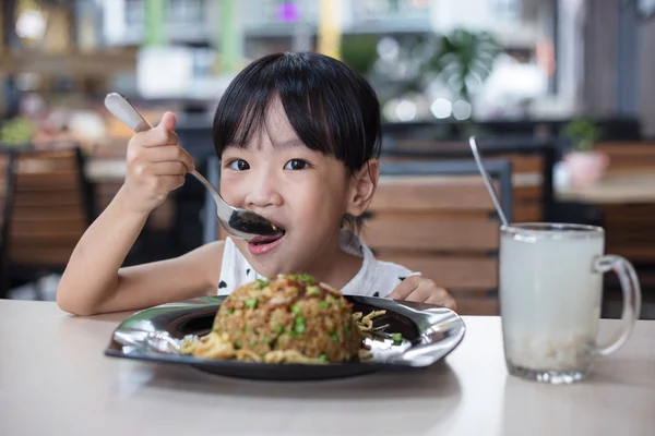 Asiatiska kinesiska lilla flicka äter stekt ris — Stockfoto