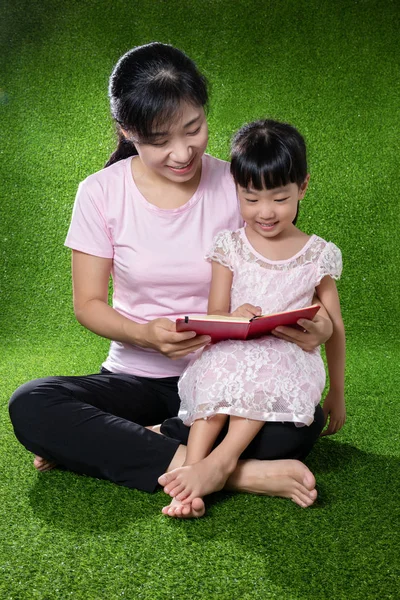 Asian Chinese mother and daughter reading the book