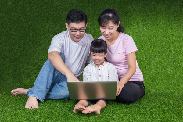 Asian Chinese parents and daughter playing laptop