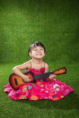 Asyalı küçük Çinli kız ile gitar çalmak