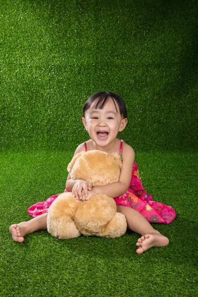 Asiático menina chinesa brincando com ursinho de pelúcia — Fotografia de Stock