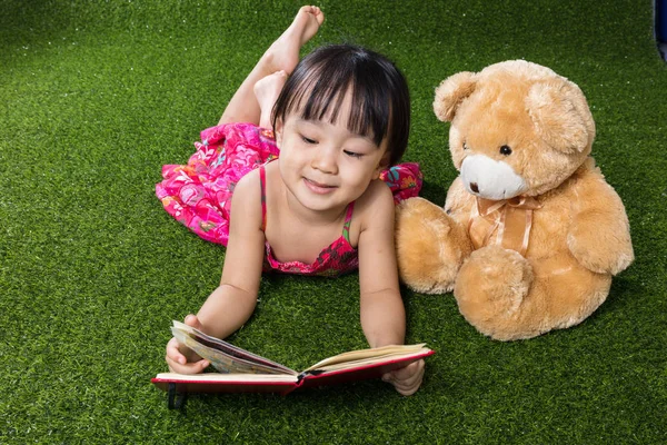 Aziatische Chinese kleine meisje leesboek met teddybeer — Stockfoto