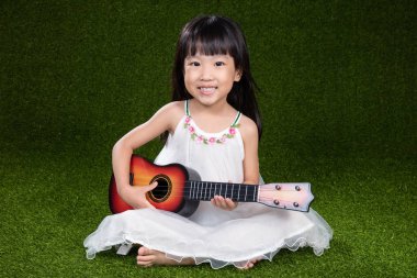 Asyalı küçük Çinli kız ile gitar çalmak