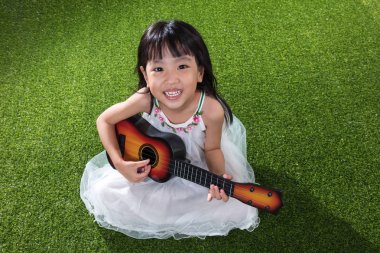 Asyalı küçük Çinli kız ile gitar çalmak