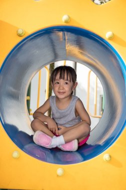 Asyalı Çinli küçük kız tünelinde oturan