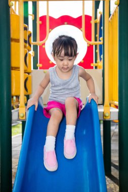 Asyalı Çinli küçük kız slayt üzerinde oynama