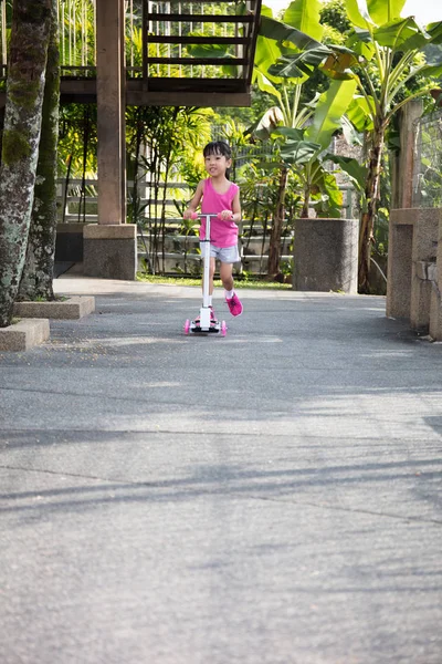 Asiático menina chinesa brincando com scooter — Fotografia de Stock