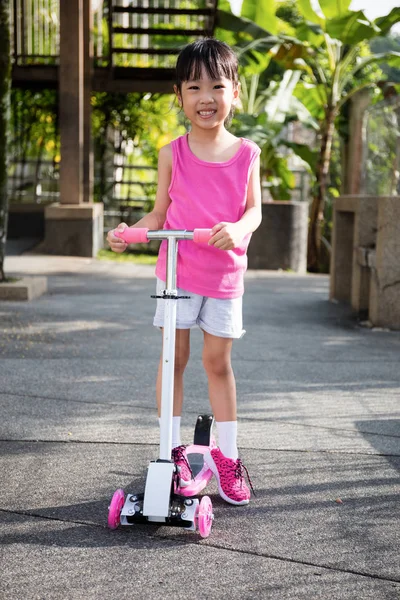 Asiatico piccolo cinese ragazza giocare con scooter — Foto Stock