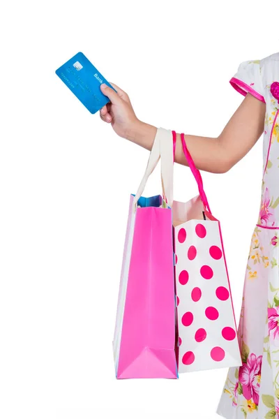 Mano del niño sosteniendo la tarjeta de crédito y coloridas bolsas de compras — Foto de Stock
