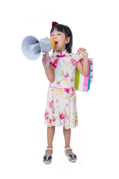 Asiatisk kinesisk lille pige holder indkøbsposer og højttaler - Stock-foto