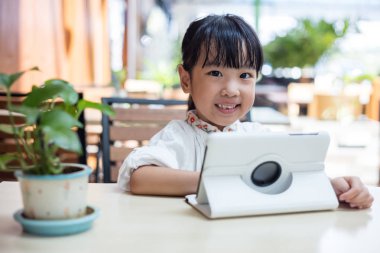 Asyalı Çinli küçük kız tablet bilgisayar oynamak
