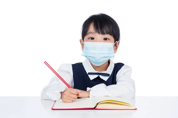 Aziatische Chinese meisje schrijven huiswerk met bescherming masker — Stockfoto