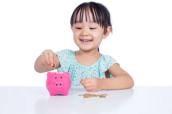 Asiático chinês menina colocando moedas no porquinho banco — Fotografia de Stock
